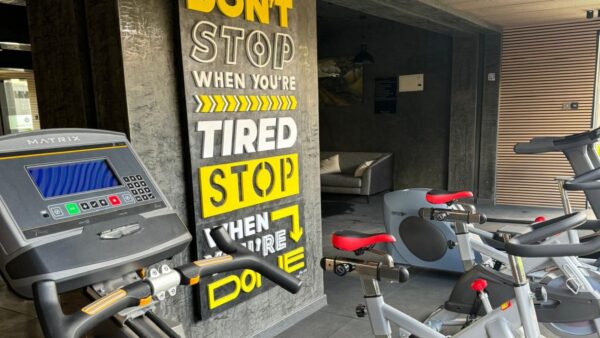 Gym with exercise bikes in front of a motivational sign reading, “Don’t stop when you’re tired, stop when you’re done.”