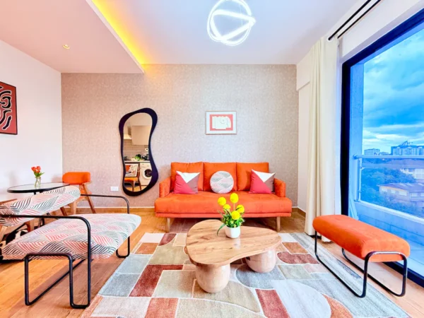 Modern living room with orange sofa, abstract mirror, geometric rug, and balcony view. Vibrant decor and curved furniture.