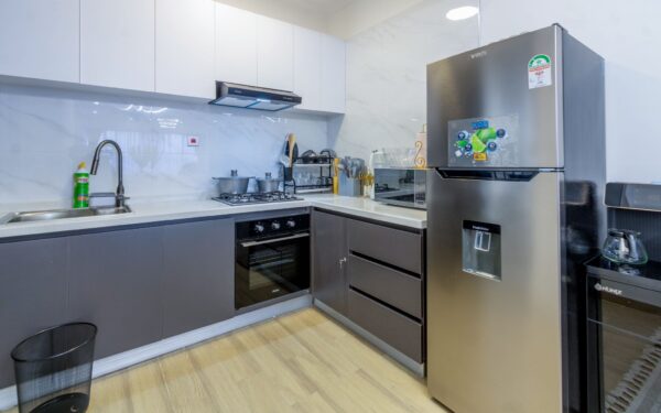 Modern kitchen with stainless steel appliances, gas stove, sleek cabinets, and marble backsplash.